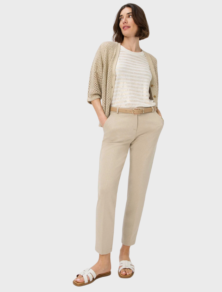A woman wearing beige trousers paired with a white shirt, exemplifying a chic and comfortable look.