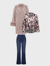 A woman wearing a white shirt and medium blue jeans stands, representing a simple yet stylish casual attire.