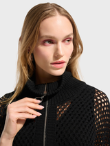 A black top on a hanger, emphasizing its timeless and adaptable fashion.