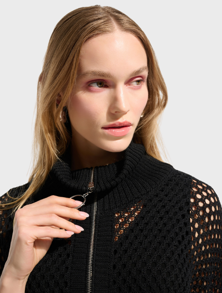 A black top on a hanger, emphasizing its timeless and adaptable fashion.