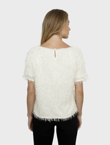 Soft vanilla knit top laid flat, showcasing its simple design and comfortable fabric ideal for casual occasions.