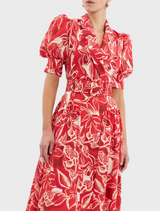 A red dress embellished with a striking white and red floral motif.