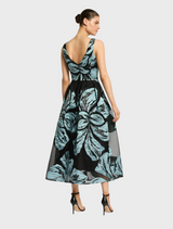 A woman showcases a blue dress and black shoes, presenting a polished and stylish appearance.