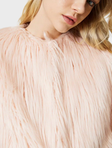 A close-up of a pink coat, emphasizing its fabric and tailored details.