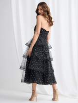 A stylish black and gold tiered dress by Ivana, emphasizing its layered design and chic appearance.