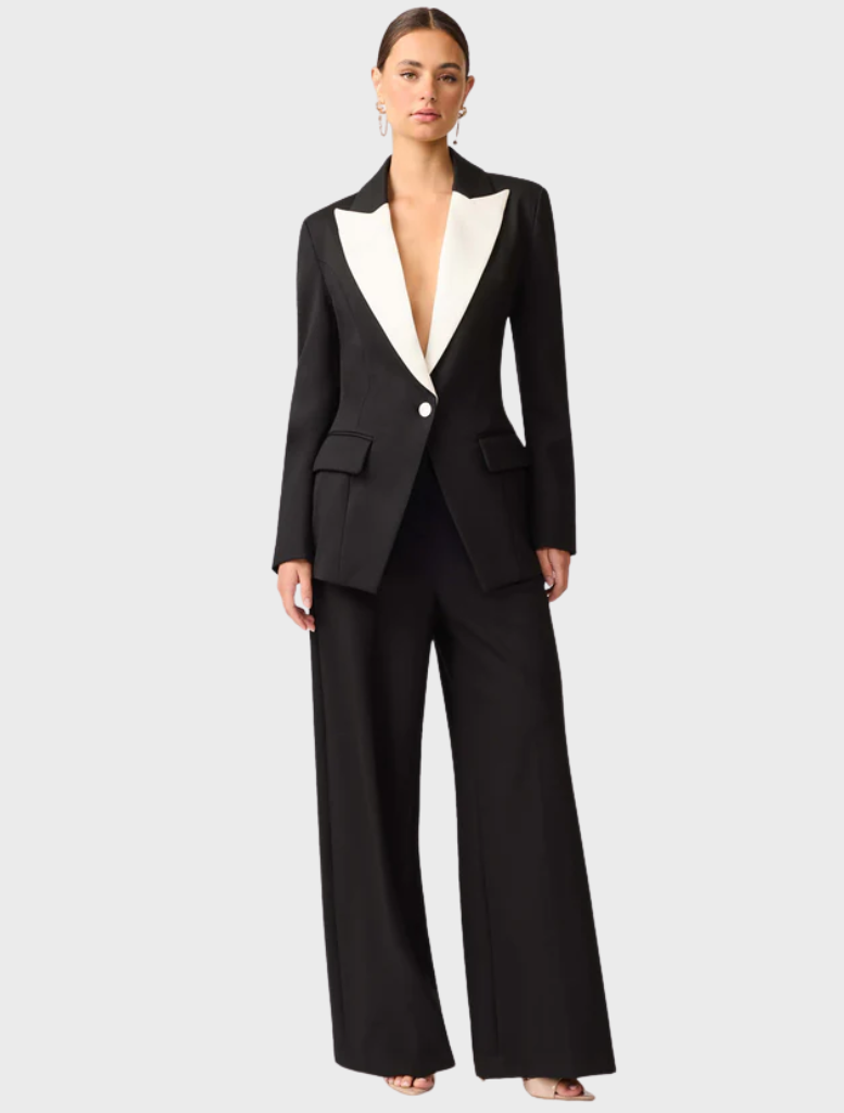 A black and white wool suit featured on a hanger, demonstrating its refined style and luxurious fabric.