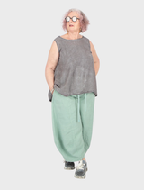 Close-up of lime linen trousers, focusing on the texture and color of the fabric.
