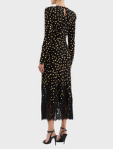 A fashionable black dress with gold polka dots, accented by lace trim for added elegance.