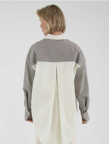 Grey Mira blouse showcased on a hanger, focusing on its fashionable style and smooth texture.