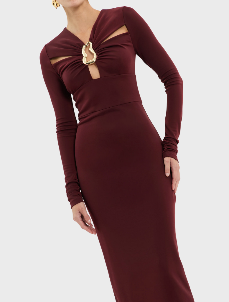  Elegant burgundy dress with long sleeves, made from stretchy fabric and highlighted by a gold chain.
