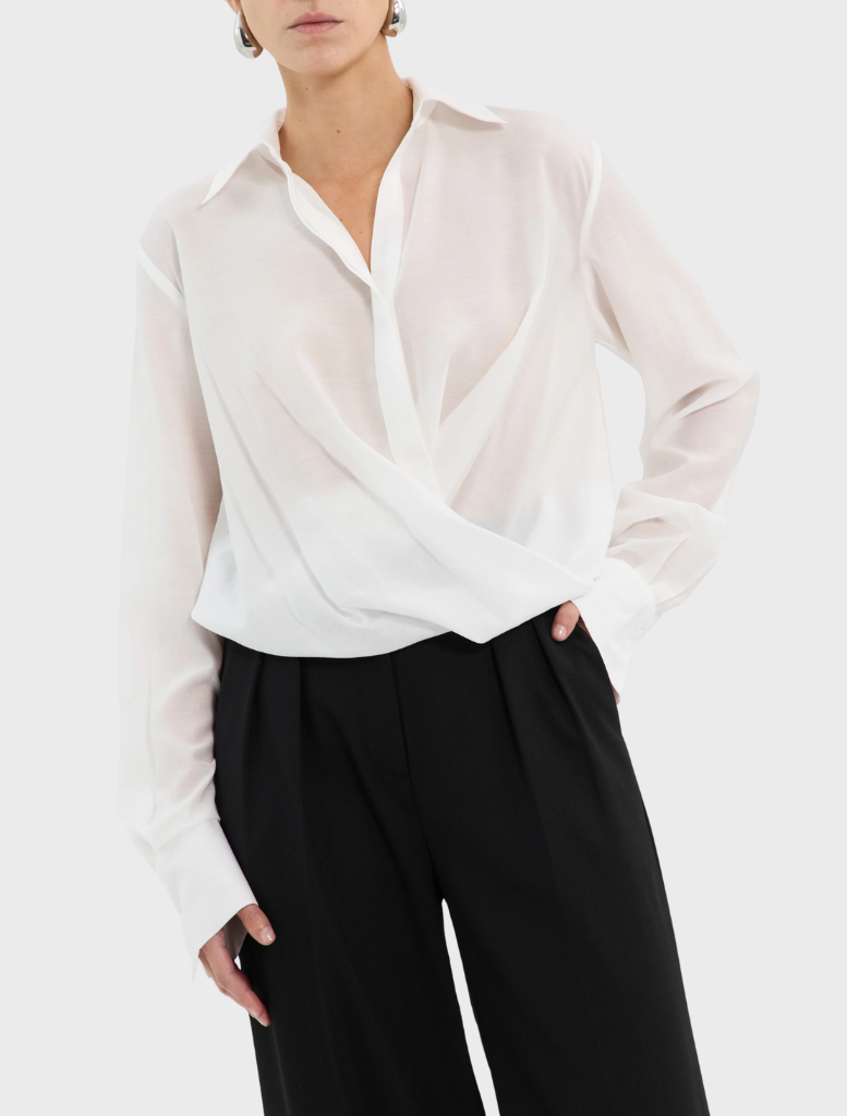 An open white shirt with long sleeves is shown, reflecting a simple and elegant design.