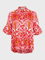 The red and white shirt gazes thoughtfully off to the side.