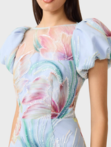 Elegant blue floral midi dress with puff sleeves, designed for a feminine silhouette and perfect for warm weather events.