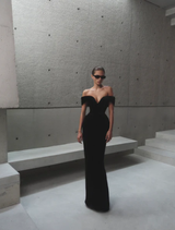 Black Ryn gown hanging on a hanger, featuring a sophisticated silhouette and delicate details.