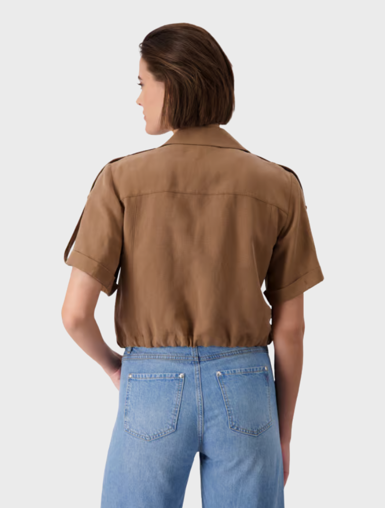 Back view of a woman in a brown collar jacket and blue jeans, showcasing a casual outfit.