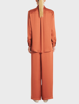 A soft copper-colored shirt displayed on a hanger, showcasing its smooth fabric and casual design.