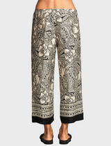 A woman in floral print pants, displaying a cheerful and stylish floral design.