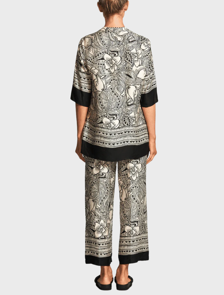A trendy top with an eye-catching elephant print, featuring intricate designs in black and gray for a bold look.