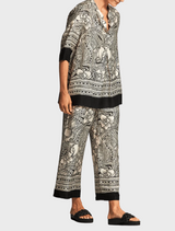 A fashionable top displaying an elephant print, characterized by detailed patterns in gray tones against a light background.