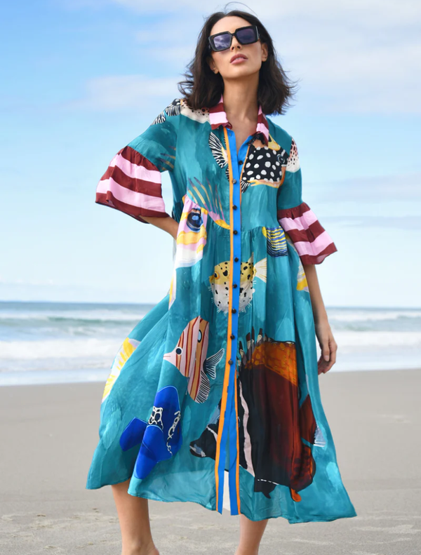 Colorful dress featuring a multi-fish print, perfect for a casual summer outing or beach day.