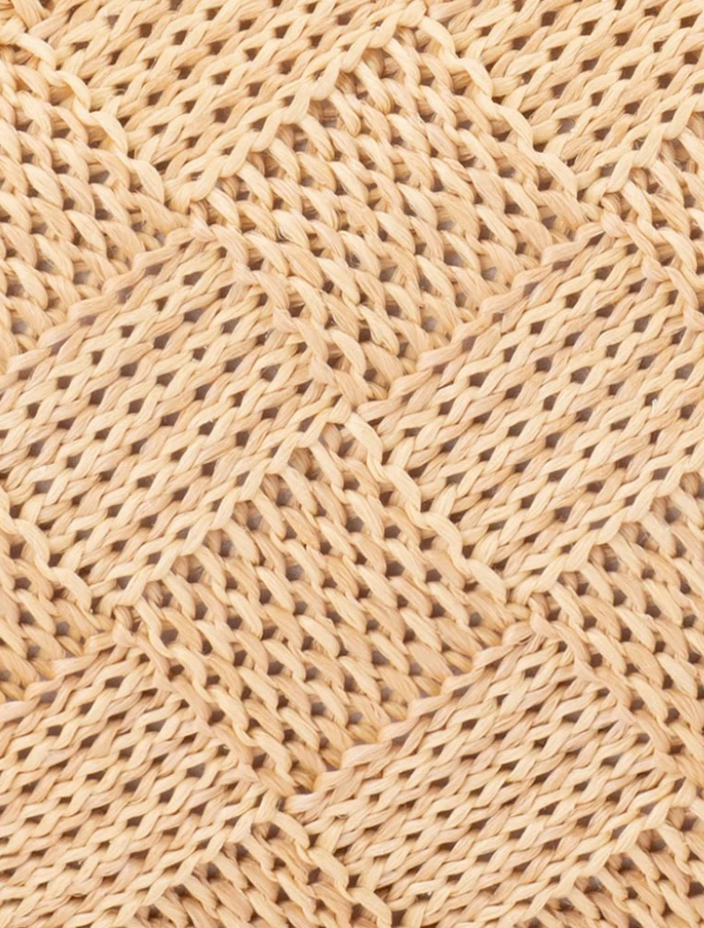 Hanging on a hook, the beige woven clutch bag Lois Woven Frame Bag - Natural is showcased.