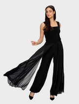 Close-up of black woven pants, focusing on the fabric's weave and the garment's structured silhouette.