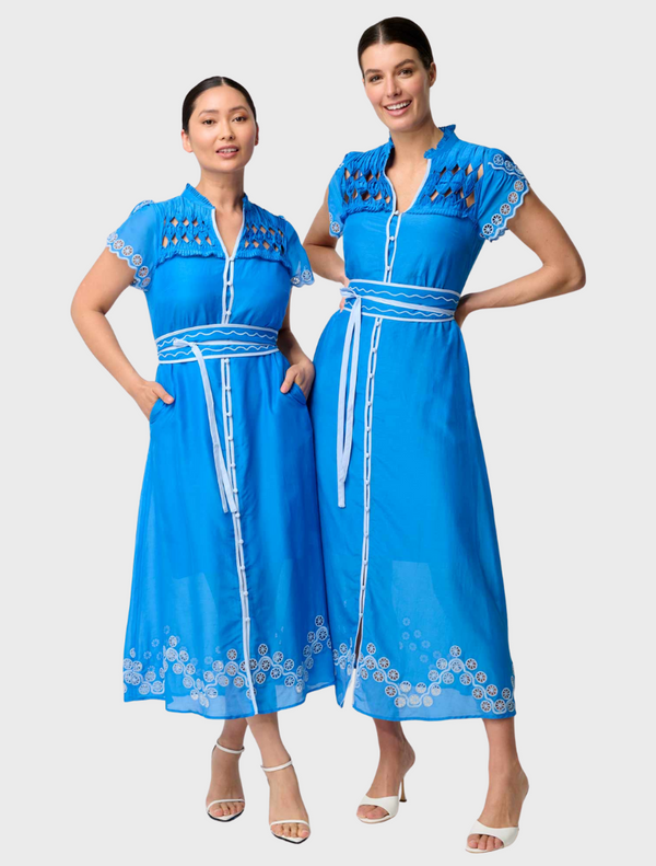 Two women in blue dresses stand side by side, showcasing the elegant Xanthia Diamond Smock Yoke Silk Cotton design.