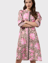The Yala Dress showcases a bold leopard and floral design, with puff sleeves, a fitted waist, and a decorative zip front.

