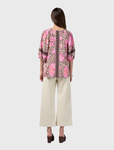 The Yala Top showcases a vibrant leopard and floral design, complete with a V-neck and relaxed puff sleeves.