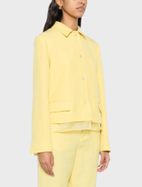Citron yellow jacket featuring a layered design, front button closure, split cuffs, and two front flap pockets.