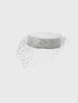 White Zahra Pillbox Hat by Morgan & Taylor, featuring a classic shape and bold veiling for a sophisticated look.