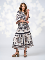 A woman in a floral print blouse stands confidently, highlighting the intricate patterns and colors.