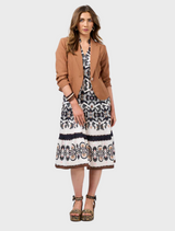  A woman dressed in an intricately patterned gown exudes elegance.