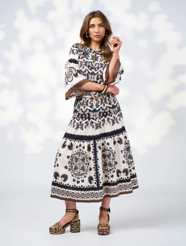  The model features a black top and a white skirt, creating a striking outfit combination.