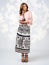 The model showcases a chic black top and a contrasting white skirt.