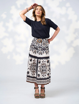  A model poses in a stylish black top paired with a flowing white skirt.