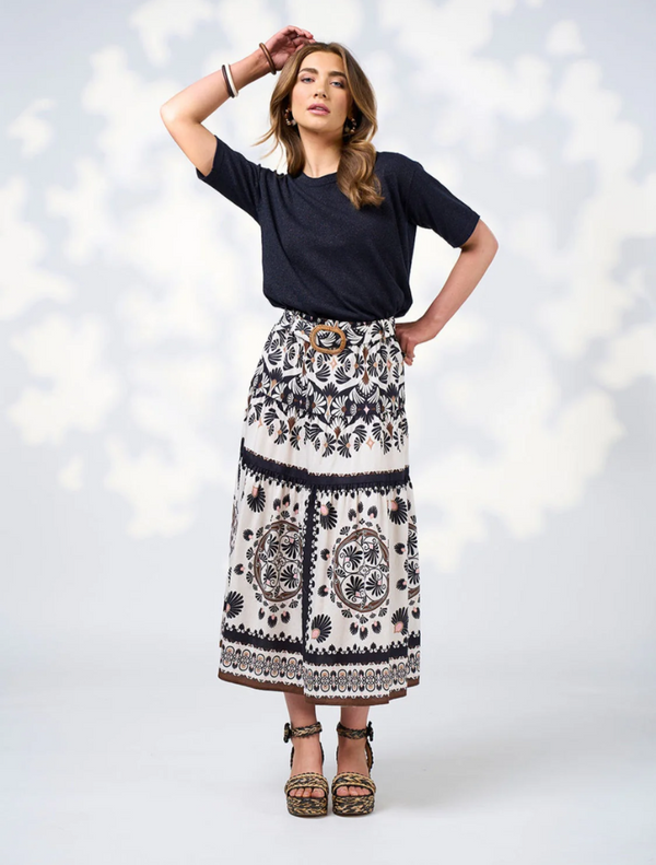  A model poses in a stylish black top paired with a flowing white skirt.